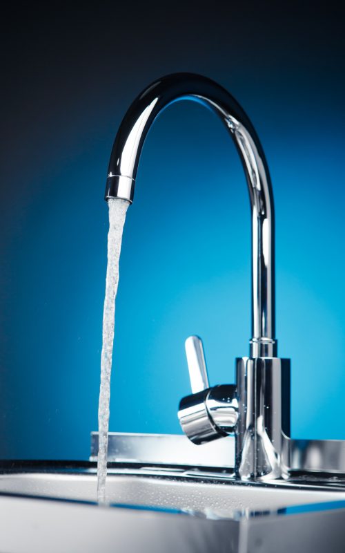 mixer tap with flowing water, blue background